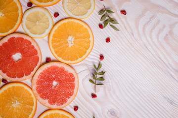 Citrus fruit cut in half - oranges, lemons, tangerines, grapefruit on a wooden background