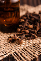 essential oil of cloves on a wooden rustic background
