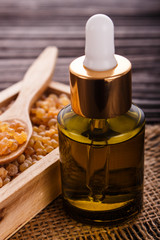 frankincense essential oil on a wooden background