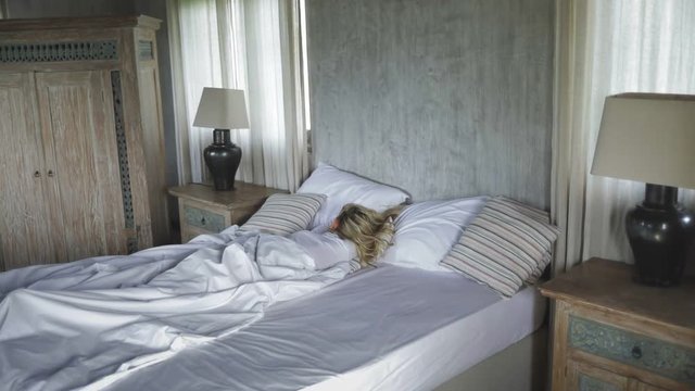 young attractive girl or woman lying on the bed, slumbering or sleeping during the day, weekend, vacation or day off