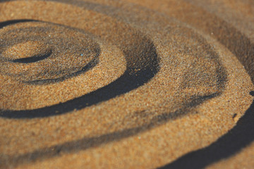 Fototapeta na wymiar Circles drawn by a finger on the sand