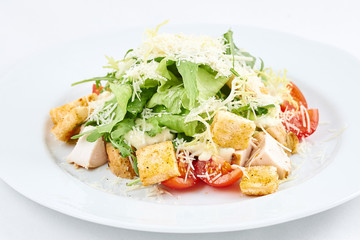 Delicious caesar salad. Tasty caesar salad with cheese, chicken, tomatoes, rusks and green leaves of arugula.