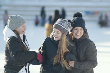 Portrait of three teenage girls wearing winter clothes in winter outside