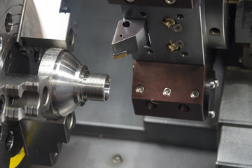 The CNC lathe machine cutting the thread at the cone shape part.