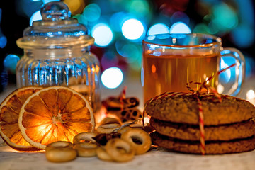 Cozy still life of tea, christmas light and pastry