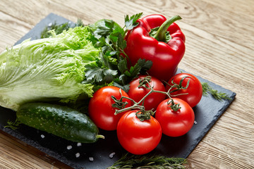 Organic closeup still life of assorted fresh vegetables and herbs on rustic wooden background, topview, selective focus.