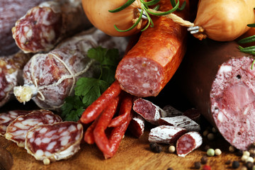 Food tray with delicious salami, ham,  fresh sausages, cucumber and herbs. Meat platter