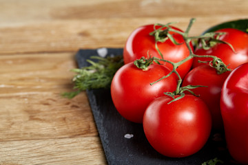 Organic closeup still life of assorted fresh vegetables and herbs on rustic wooden background, topview, selective focus.