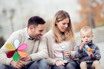 Happy young family in city street,having fun.