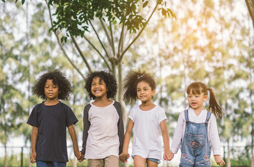 Children Friendship Togetherness Smiling Happiness Concept.Cute african american little boy and girl walking and hold hand in summer sunny day