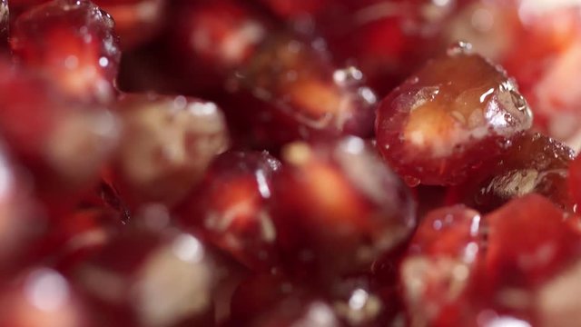 Bright juicy pomegranate. Pomegranate grains on a white background. Macro. macro shooting. Seeds of pomegranate turn in a shot. Red grains