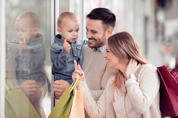 Happy family with shopping bags wach showcases