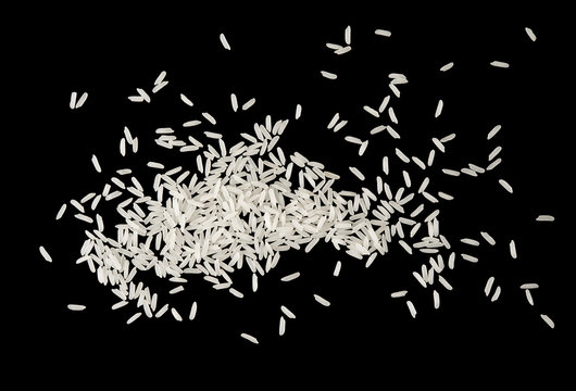 Pile of white raw rice splash isolated on black background on top view