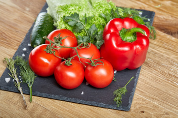 Organic closeup still life of assorted fresh vegetables and herbs on rustic wooden background, topview, selective focus.