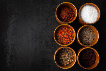 Set of spices on dark grey background.  Food art concept. Composition of bottles with colored herbs and spices.