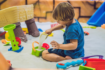 Boy playing with sand in preschool. The development of fine motor concept. Creativity Game concept