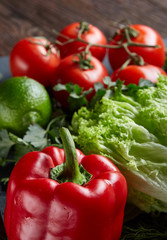 Close-up still life of assorted fresh vegetables and herbs on vintage wooden background, top view, selective focus.
