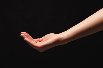 Woman holding palm open isolated on black
