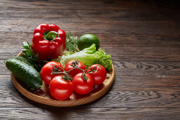 Close-up still life of assorted fresh vegetables and herbs on vintage wooden background, top view, selective focus.