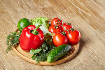 Close-up still life of assorted fresh vegetables and herbs on vintage wooden background, top view, selective focus.
