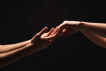 Hands of man and woman in love, isolated on black