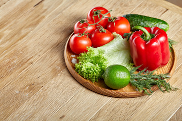 Close-up still life of assorted fresh vegetables and herbs on vintage wooden background, top view, selective focus.