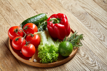 Close-up still life of assorted fresh vegetables and herbs on vintage wooden background, top view, selective focus.