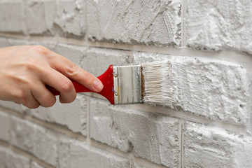 ladies hand painted brick brush white wall.