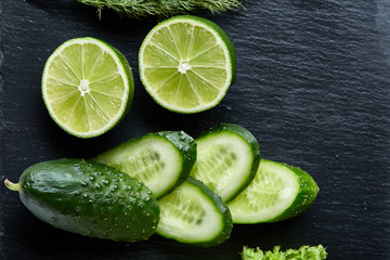 Concept of fresh green lettuce, cucumber, dill, lime on a light background, selective focus, top view, copy space.