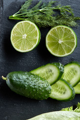 Concept of fresh green lettuce, cucumber, dill, lime on a light background, selective focus, top view, copy space.
