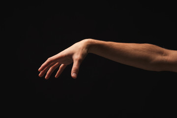 Male hand picking up something, cutout on black