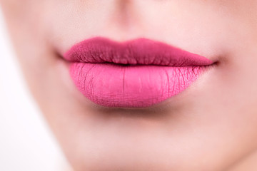 Fototapeta premium Close up of pink lips, a smile on the woman's face. Cosmetics, lipstick, lip gloss, detail, macro photo.