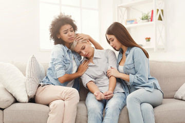 Naklejka na ściany i meble Three young female friends chatting at home