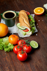 Lunch sandwich with cheese and vegetables served with citrus and coffee, selective focus, close-up, top view