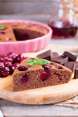 A piece of chocolate pie with a cherry on a table