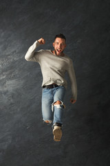 Fototapeta na wymiar Happy handsome man jumping in studio