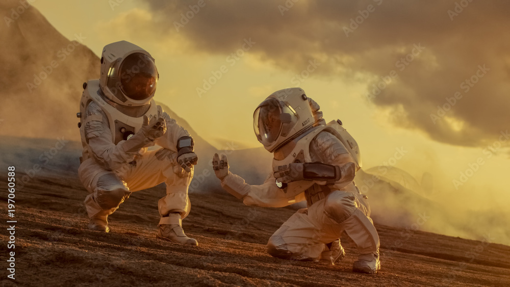 Wall mural two astronauts collect soils samples on alien planet, analyzing them with hands computer. mars/ red 