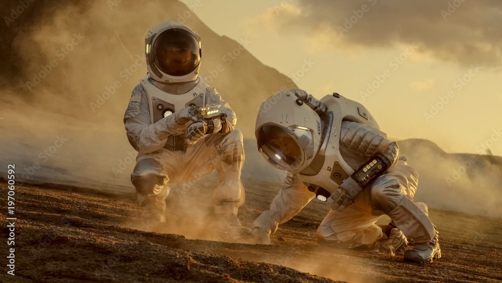Wall mural two astronauts collect soils samples on alien planet, analyzing them with hands computer. mars/ red 