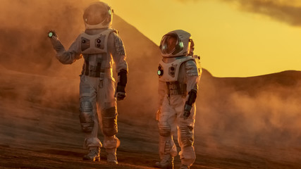 Two Astronauts Wearing Space Suits Walk Exploring Mars/ Red Planet. Space Travel and Solar System Colonization Concept.