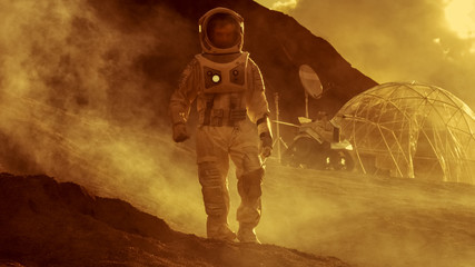 Astronaut on Mars Walking on the Exploring Expedition. In the Background His Base/ Research...