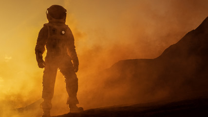 Brave Astronaut Confidently Walks on Mars Surface. Red Planet Covered in Gas and rock,  Overcoming Difficulties, Important Moment for the Human Race. - obrazy, fototapety, plakaty