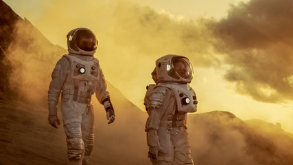 Two Astronauts in Space Suits Confidently Walking on Mars, Exploration Expedition on the Planet's...