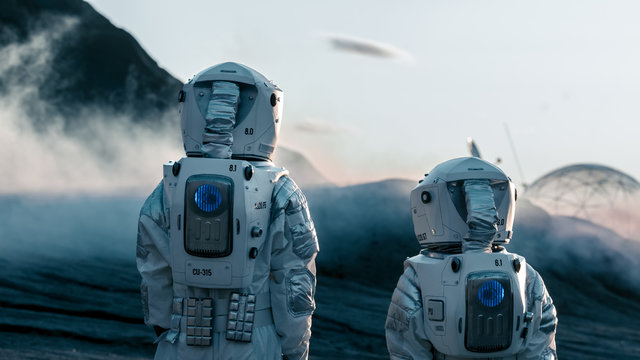 Shot of Two Astronauts Confidently Walking on Alien Rocky Planet that is Covered with Gas and Smoke. Humans Overcoming Difficulties. Scientific Progress. - Powered by Adobe