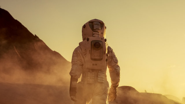 Shot of Astronaut Confidently Walking on Mars. Red Planet Covered in Gas and Smoke. Humans Overcoming Difficulties. Big Moment for the Human Race.