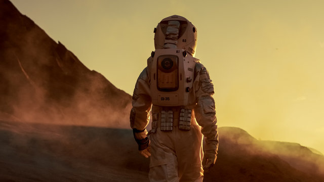 Shot of Astronaut Confidently Walking on Mars. Red Planet Covered in Gas and Smoke. Humans Overcoming Difficulties. Big Moment for the Human Race.