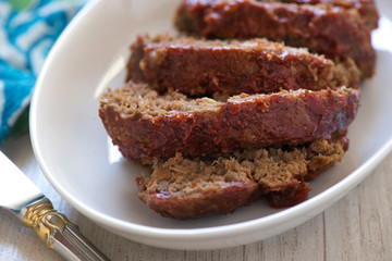 Sliced meatloaf on a white platter