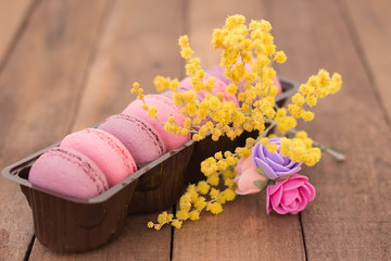 sweet French macarons in a package with flowers and Mimosa
