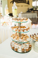 Delicious and tasty dessert table with cupcakes shots at reception closeup