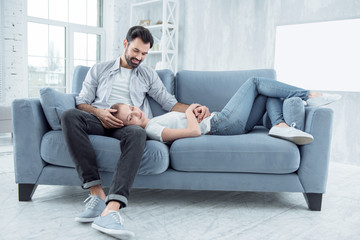 Dreamy mood. Handsome brunette male bowing head while looking at his girl and touching her head