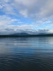 Scenic sunset with blue sky and white clouds during boat ride excursion of the mangrove wetland of the Caroni Swamp and Bird Sanctuary on the Caribbean island of Trinidad & Tobago (West Indies)